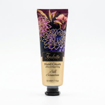 שפופרת קרם ידיים סילק סנסיישן פרולטה Frulatte Silk Sensation Intensive Hand Cream בנפח 50 מ"ל, המעניק לחות אינטנסיבית ומגע משי עם שמן אבוקדו וקמומיל, בעיצוב בגווני סגול משי וירוק בוטני.